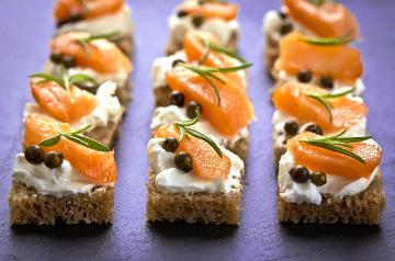 image of bread with layer of cheese, capers, lox, rosemary